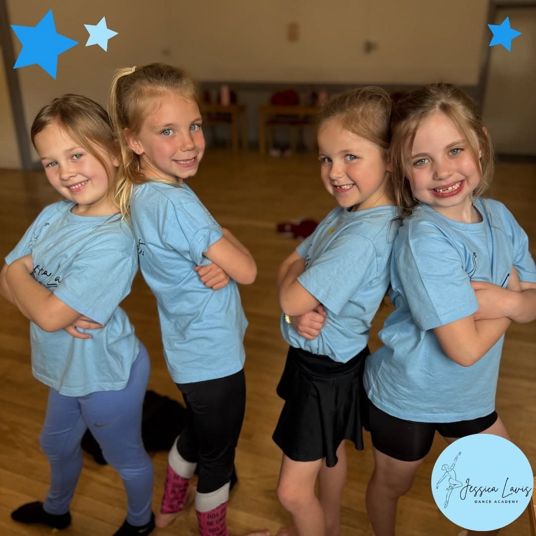 Four young dancers posing back to back in pairs in the studio