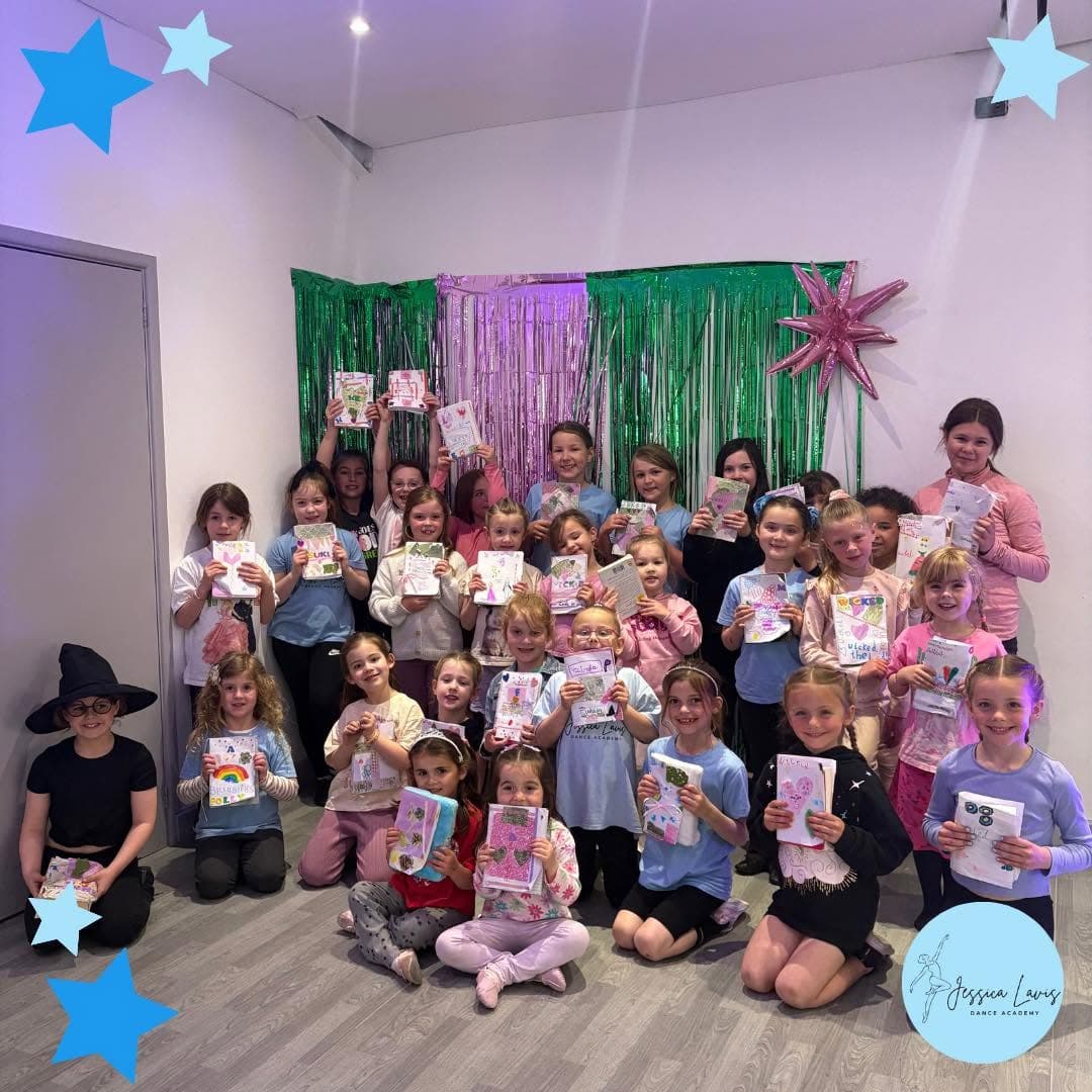 A big group of children proudly holding up crafts they made at a themed holiday workshop